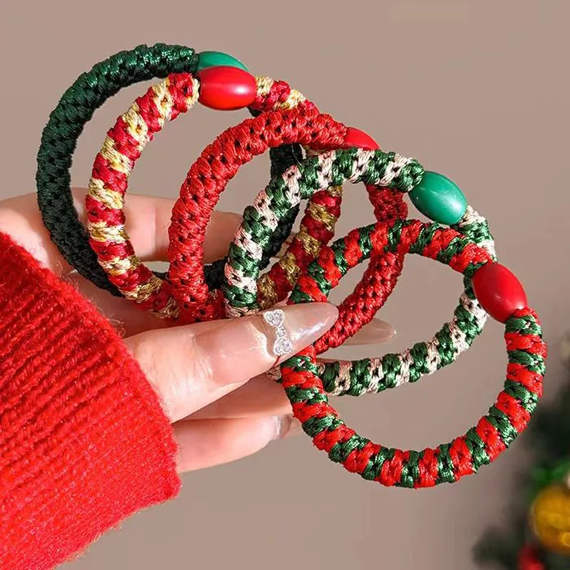 Christmas-colour braided hair ties held in a hand